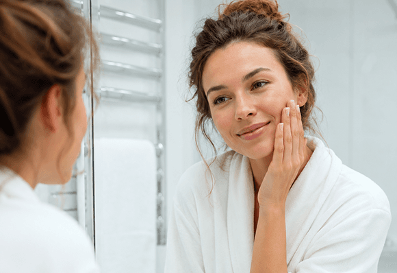Woman looking in the mirror during her morning routine